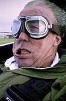 Pilot in goggles with his face distorted by wind and G-force