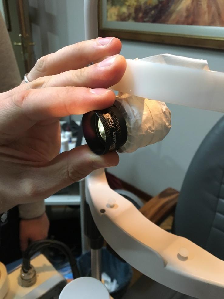 Volk lens held in front of the practice eye on the slit lamp head rest